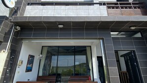 Un bâtiment moderne doté d’un toit plat, de grandes fenêtres et d’une entrée carrelée.