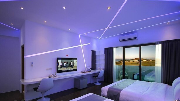 Une chambre d ’hôtel moderne équipée d’un grand lit, d’un bureau, d’une chaise et d’un téléviseur.
