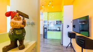 Una cocina con un armario verde, un refrigerador blanco y un altavoz negro.