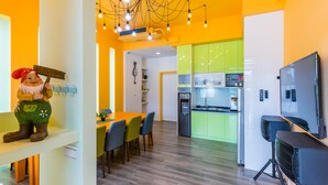 Una cocina moderna con nevera integrada y una zona de comedor con mesa y sillas.