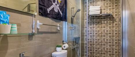 A bathroom with a shower, a toilet, and a bidet.