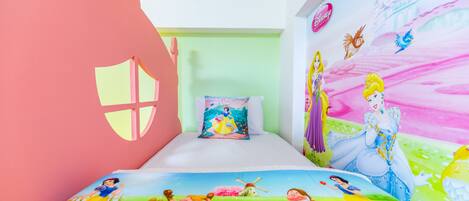 A children's bedroom with Disney-themed decorations, including a mural and bedding.