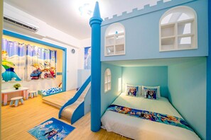 Una habitación infantil con una cama temática de castillo, una zona de juegos con un tobogán y una ventana con vistas al exterior.