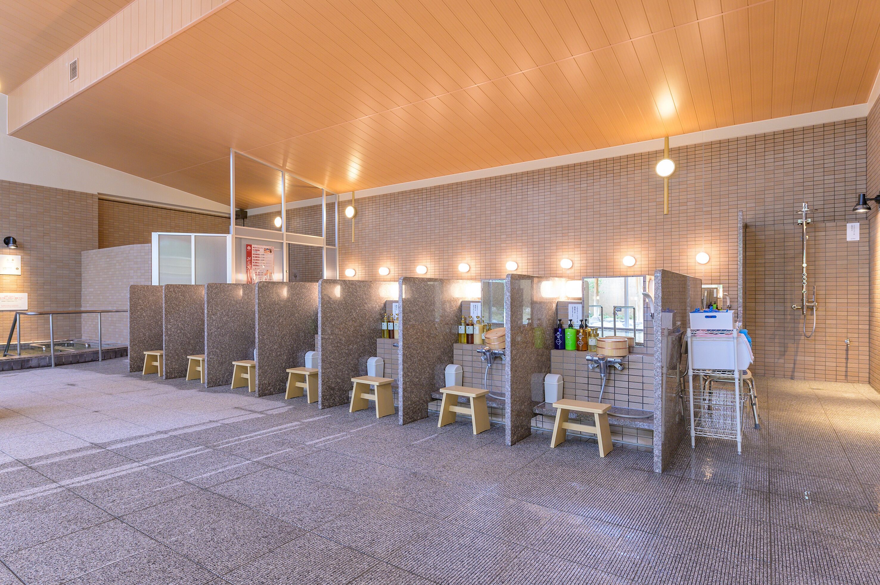 A public restroom with multiple stalls, a sink area, and a handwashing station.