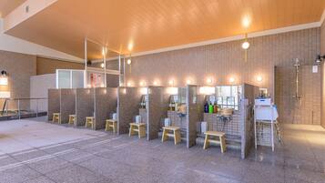 A public restroom with multiple stalls, a sink area, and a handwashing station.