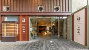 Een modern gebouw met een houten gevel en glazen entree.