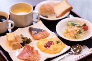 A tray with a variety of breakfast items including toast, eggs, ham, and a bowl of salad. - Hotel Kyoto Eminence (Kyoto)