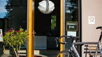 Entrada moderna de un edificio con una bicicleta estacionada afuera.