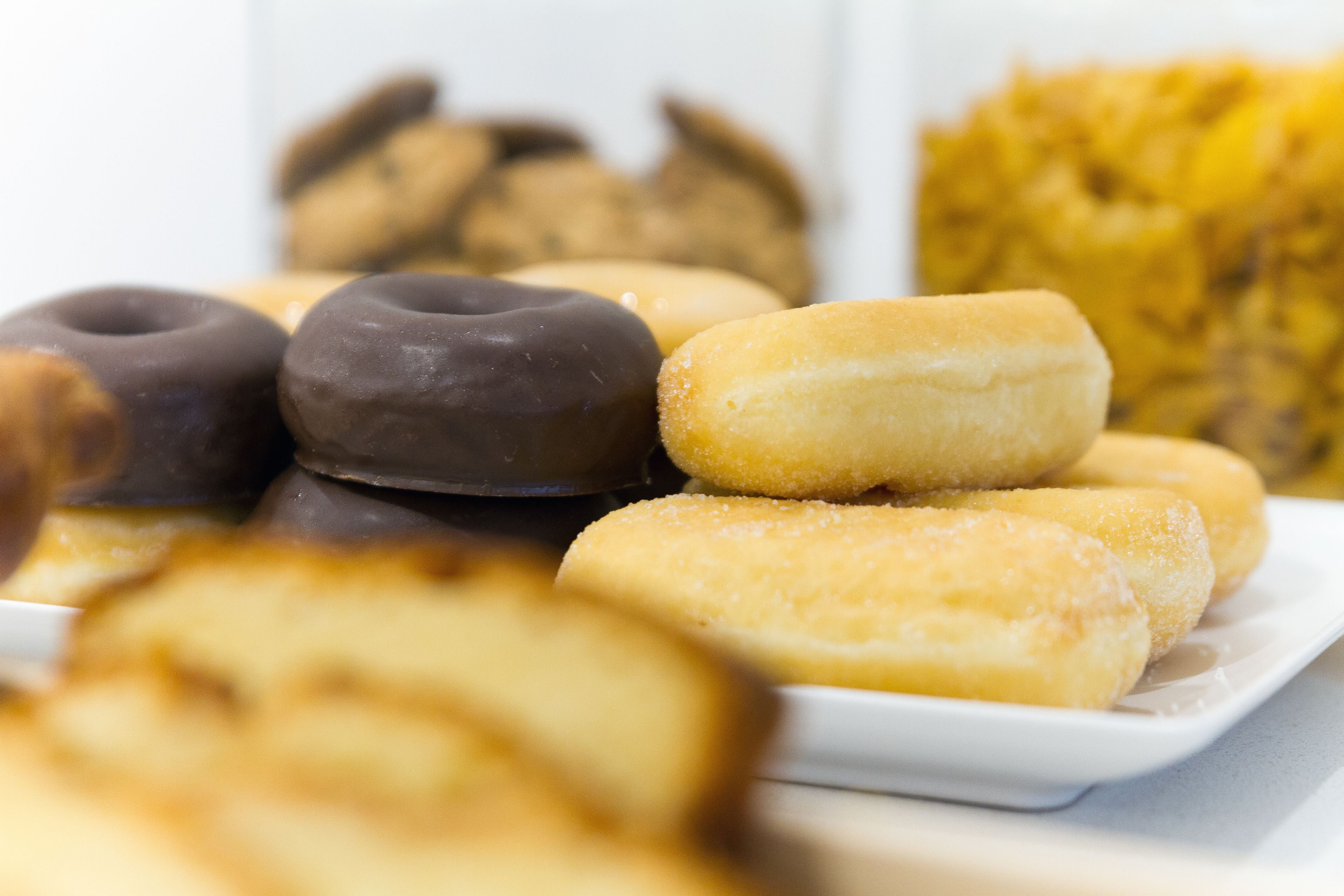 Un plato de donas variadas con glaseado de chocolate y azúcar.