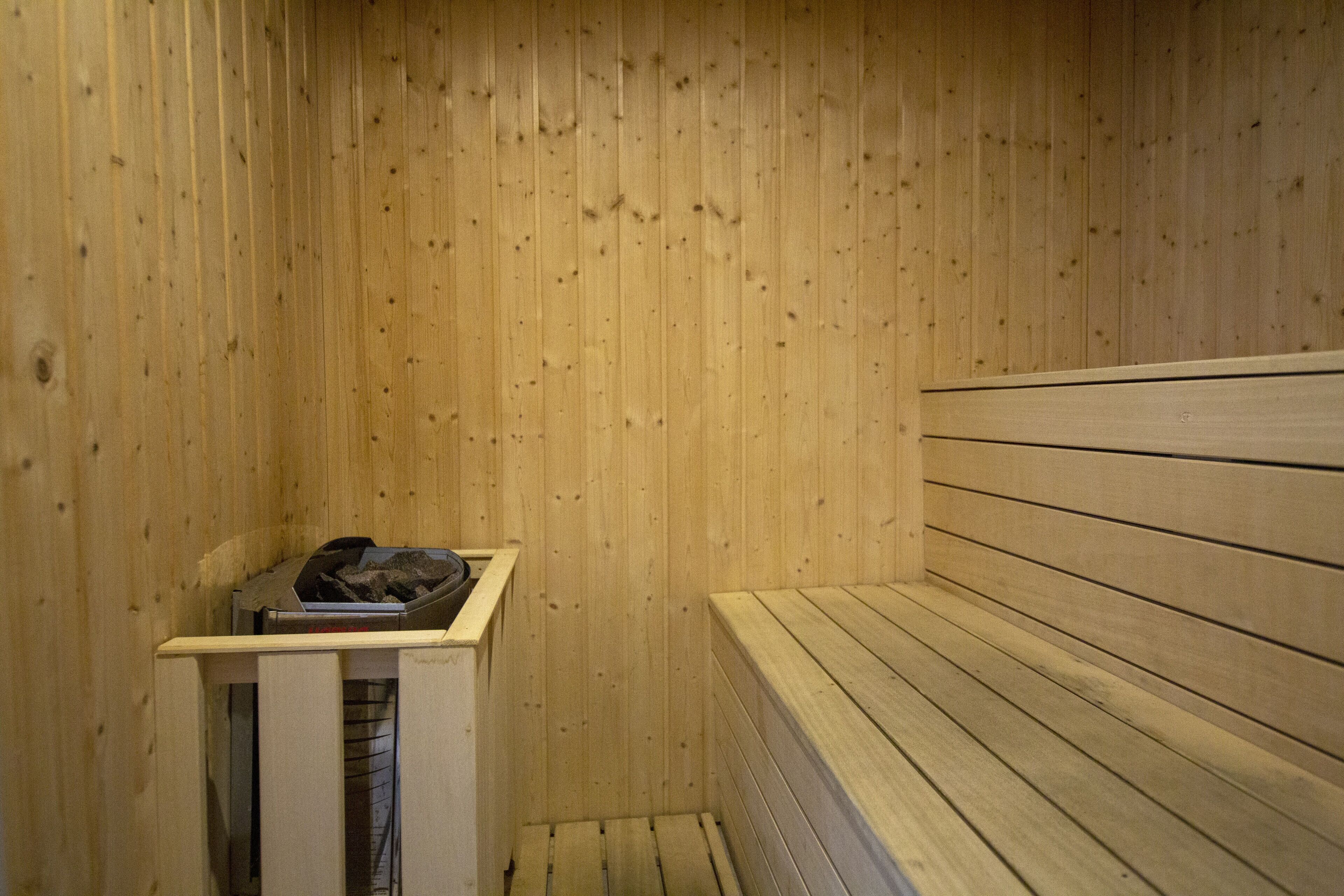 Een houten sauna met banken en een tafeltje.
