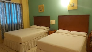 Ein Hotelzimmer mit zwei Betten, einem Nachttisch mit Lampe und einem Bild an der Wand.
