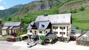 A hotel with a central building, a bell tower, and a greenhouse. - Hotel Edelweiss (Naut Aran)