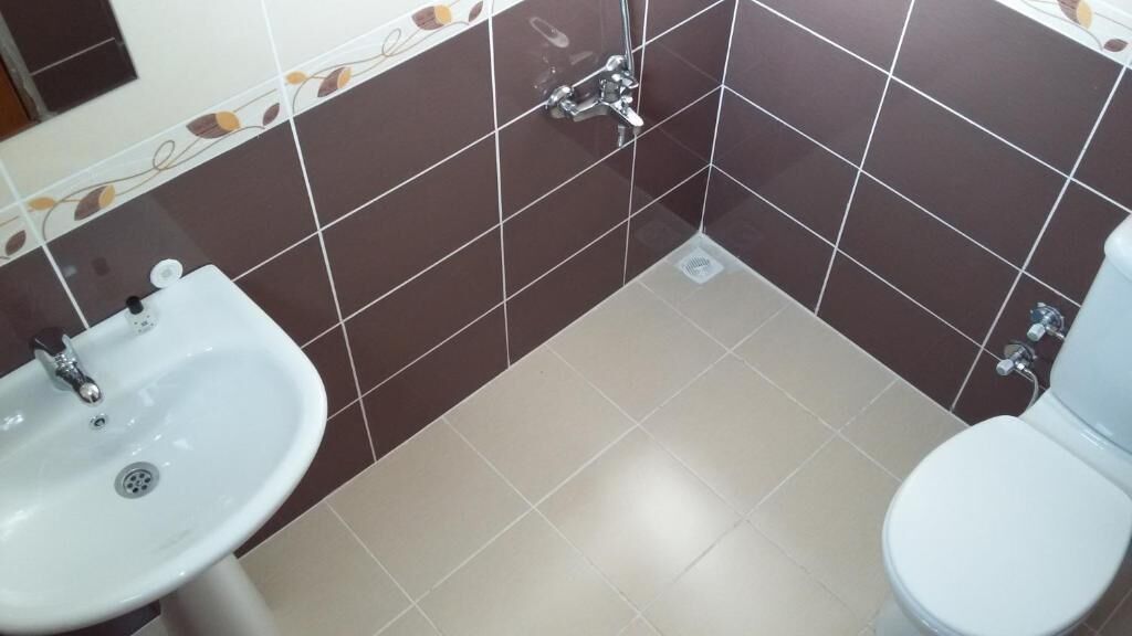 Un baño con lavamanos, inodoro y ducha.