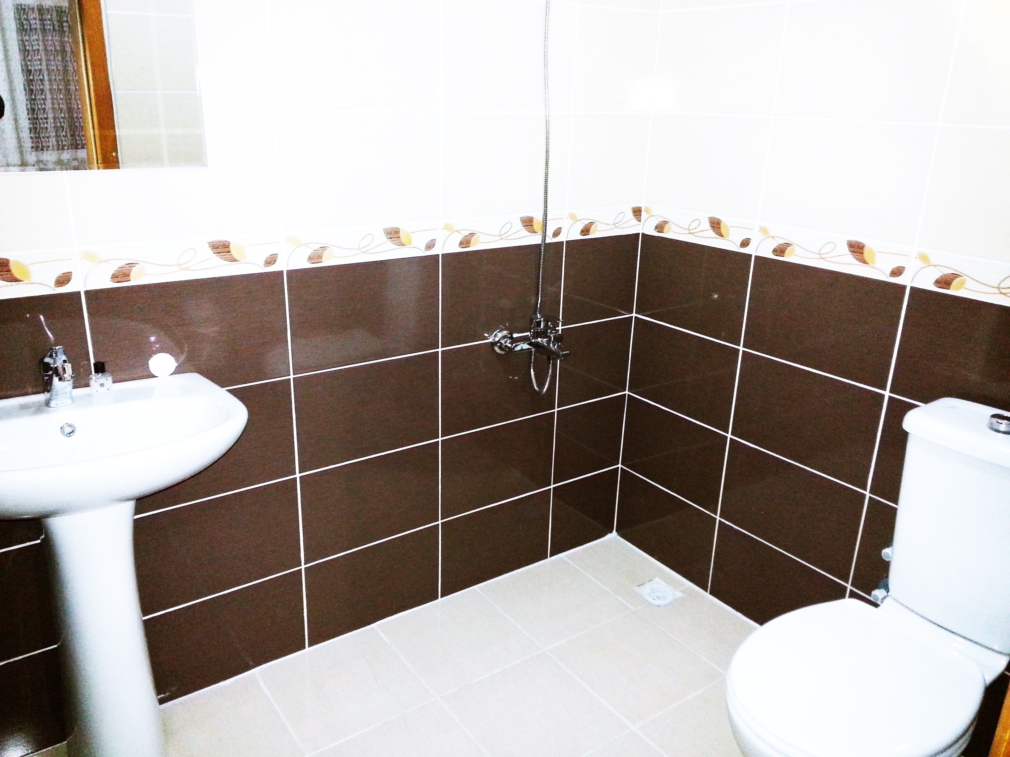 A bathroom with a sink, toilet, and shower.