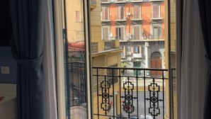 Un balcón con vista a un edificio con balcones y una calle abajo.
