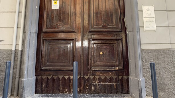 Una puerta doble de madera grande con tallas intrincadas y un cartel que indica el año 1909.