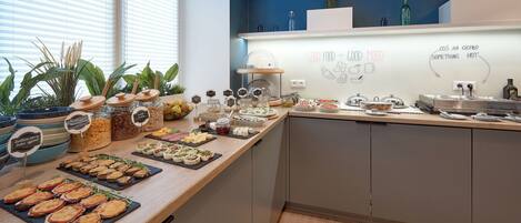 A buffet setup with various food items and a whiteboard with motivational writing.