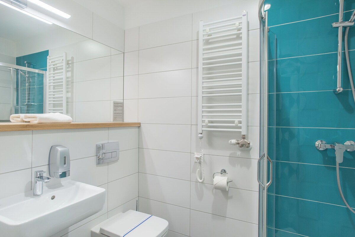 A modern bathroom with a sink, toilet, and shower.