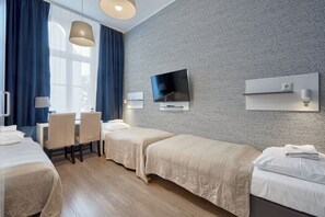 A hotel room with a bed, a desk, a chair, a TV, and a patterned wall. - Hotel Traffic Wrocław Stare Miasto (Wroclaw)