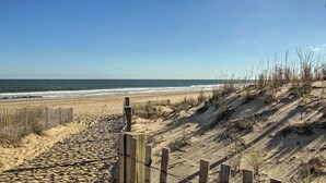 A sandy beach with a wooden fence and dunes. - Stroll to Shore! Condo w/ Balcony in Ocean City (Ocean City)
