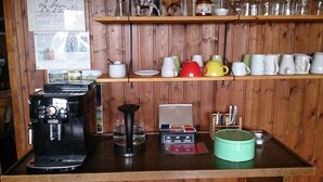 Een keukenblad met een koffiezetapparaat, een waterkoker, een theeset en een groene theepot.