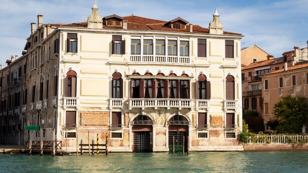 A historic building with a balcony, arched windows, and a water canal in front. - Granda Sweet Suites (Venice)
