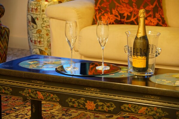 A table with a bottle of champagne, two glasses, and a decorative tray. - Granda Sweet Suites (Venice)
