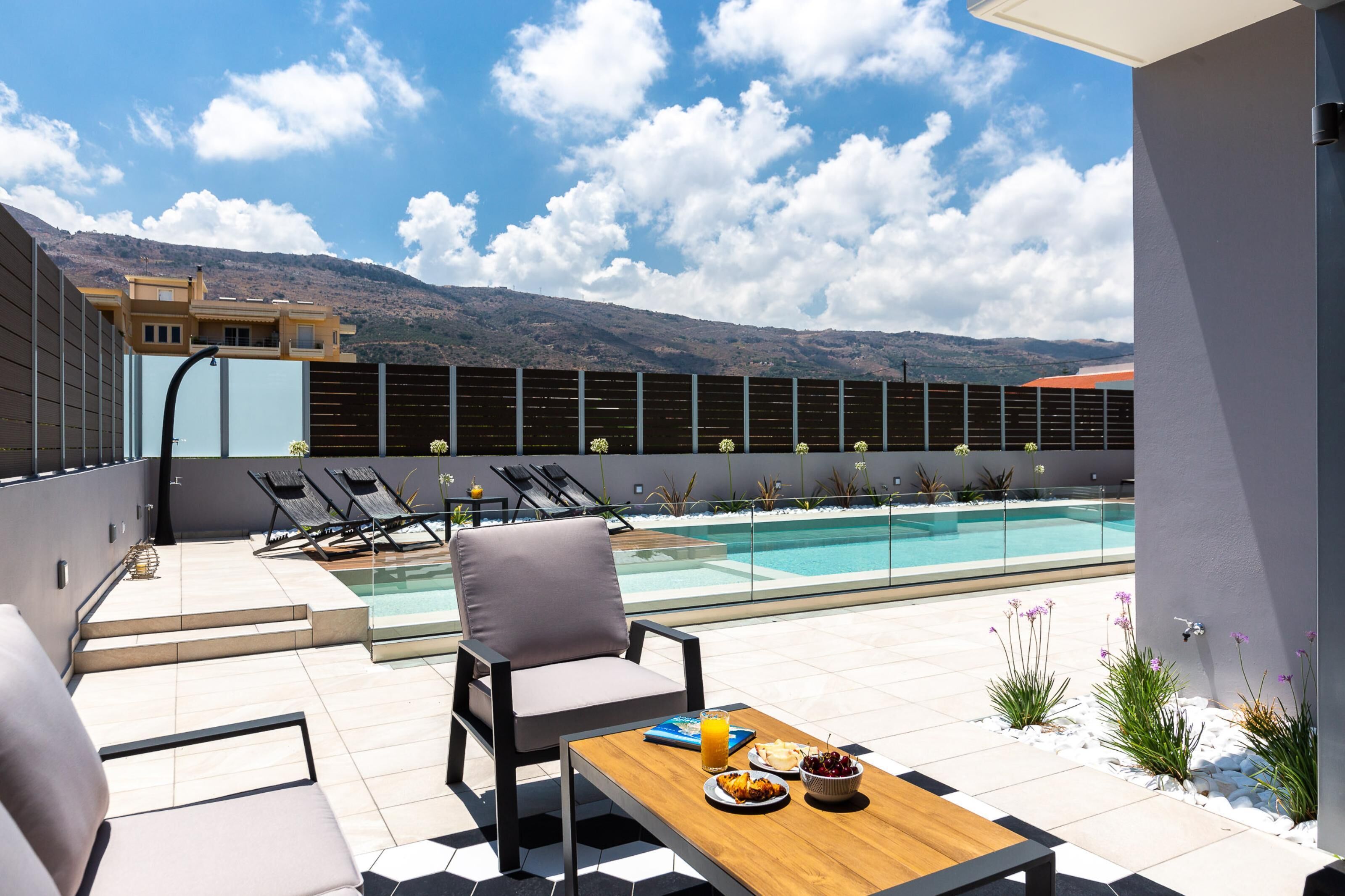 Una piscina al aire libre, sillones reclinables de piscina