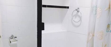Un baño con lavamanos, inodoro y espejo blancos.