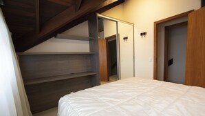 A bedroom with a bed, wooden shelves, and a closet with a sliding door. - My Home - Copenhague (Gramado)