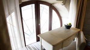 A corner desk with a basket containing an apple, a bench with a striped cushion, and a window with a decorative iron grille. - Oca Ribeira do Porto Hotel (Porto)