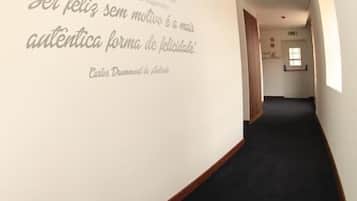 Ein Korridor mit einer gewölbten Wand, die ein Zitat in Portugiesisch zeigt.