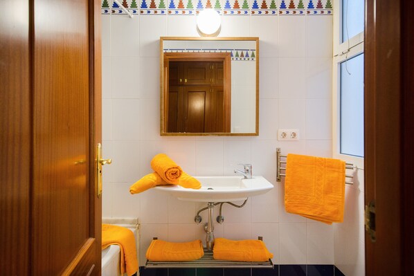 A bathroom with a sink, mirror, and towel rack.