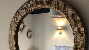 A round mirror with a textured frame on a wall. - Il Etait Une Fois à L'Ouest (Plestan)
