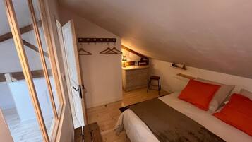 Un dormitorio con cama, escritorio y silla.