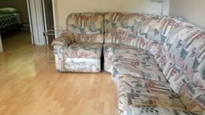 Ein Wohnzimmer mit einem gemusterten Sofa und einer Lampe.