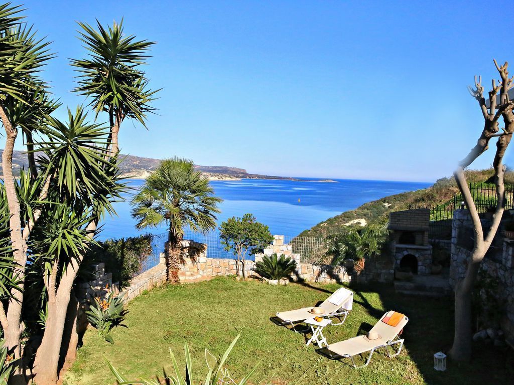Un patio con dos tumbonas frente a una vista costera.