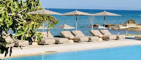 Een buitenzwembad, parasols voor strand/zwembad