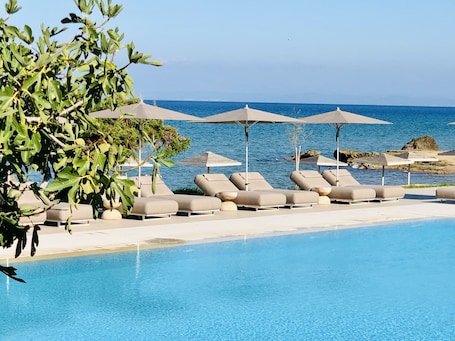 Outdoor pool, pool umbrellas, pool loungers. The Bay Hotel & Suites