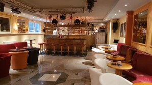A bar area with stools, a counter, and a seating area with tables and chairs. - Hotel zur Engelsburg (Hausen)