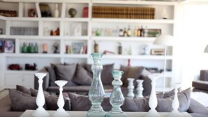 A living room with a sofa, a coffee table, and decorative vases. - Casa Bikini (Manatiales)