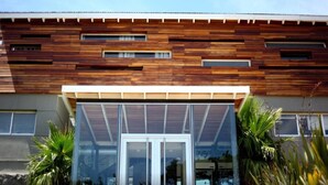 A modern building with a wooden facade and large glass entrance. - Casa Bikini (Manatiales)