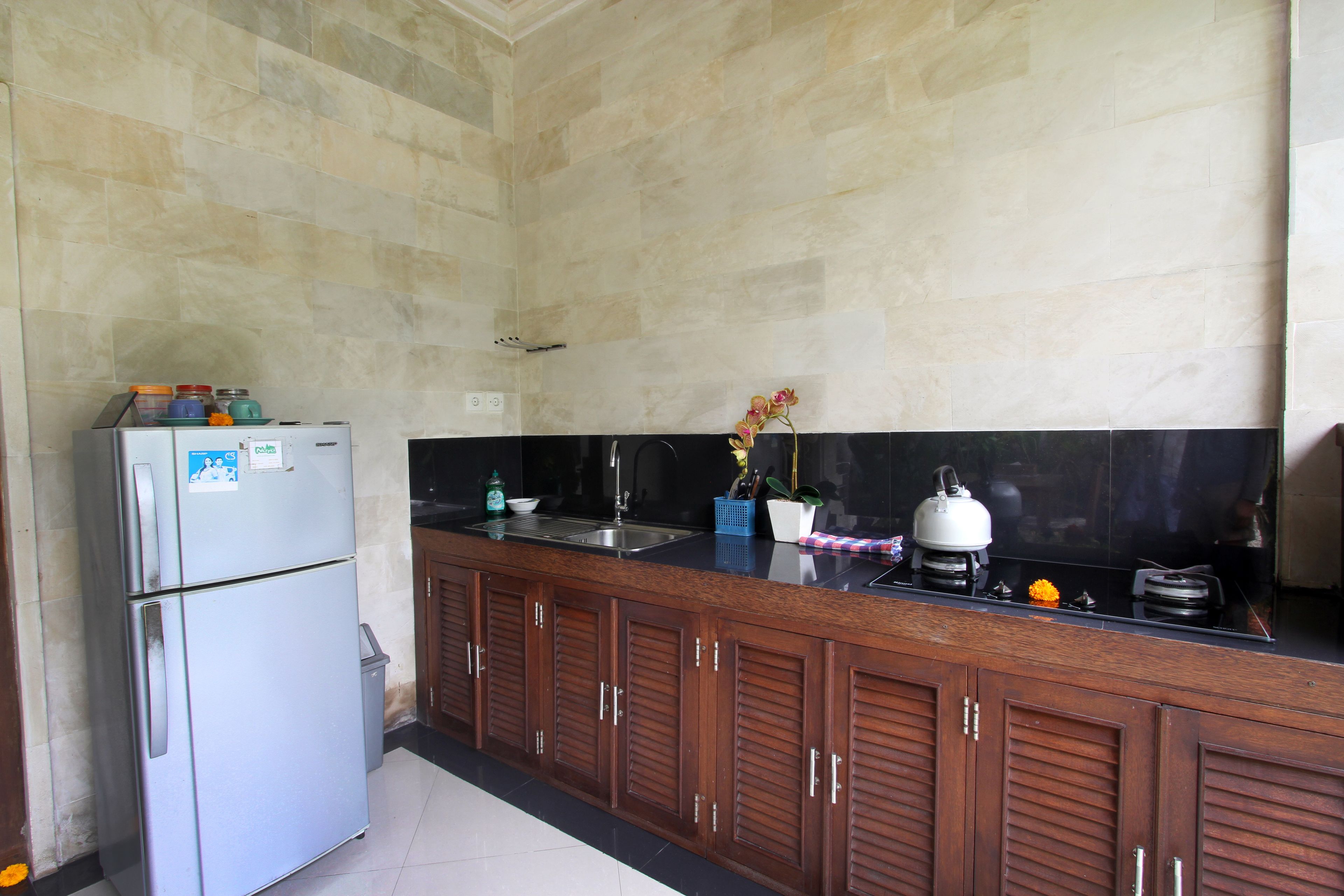 A kitchen with a refrigerator, sink, and stove.
