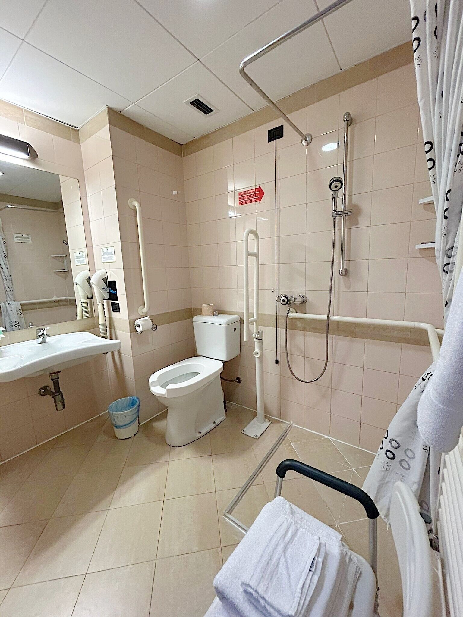 Een badkamer met toilet, wastafel en douche.