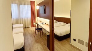 Une chambre d’hôtel équipée d’un lit, d’un bureau, d’une chaise et d’un téléviseur.