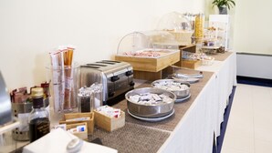 Een buffetopstelling met verschillende gerechten, een broodrooster en een koffiehoek.