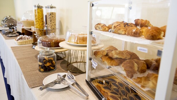 Un buffet de petit-déjeuner proposant un assortiment de viennoiseries, de pains et de condiments.