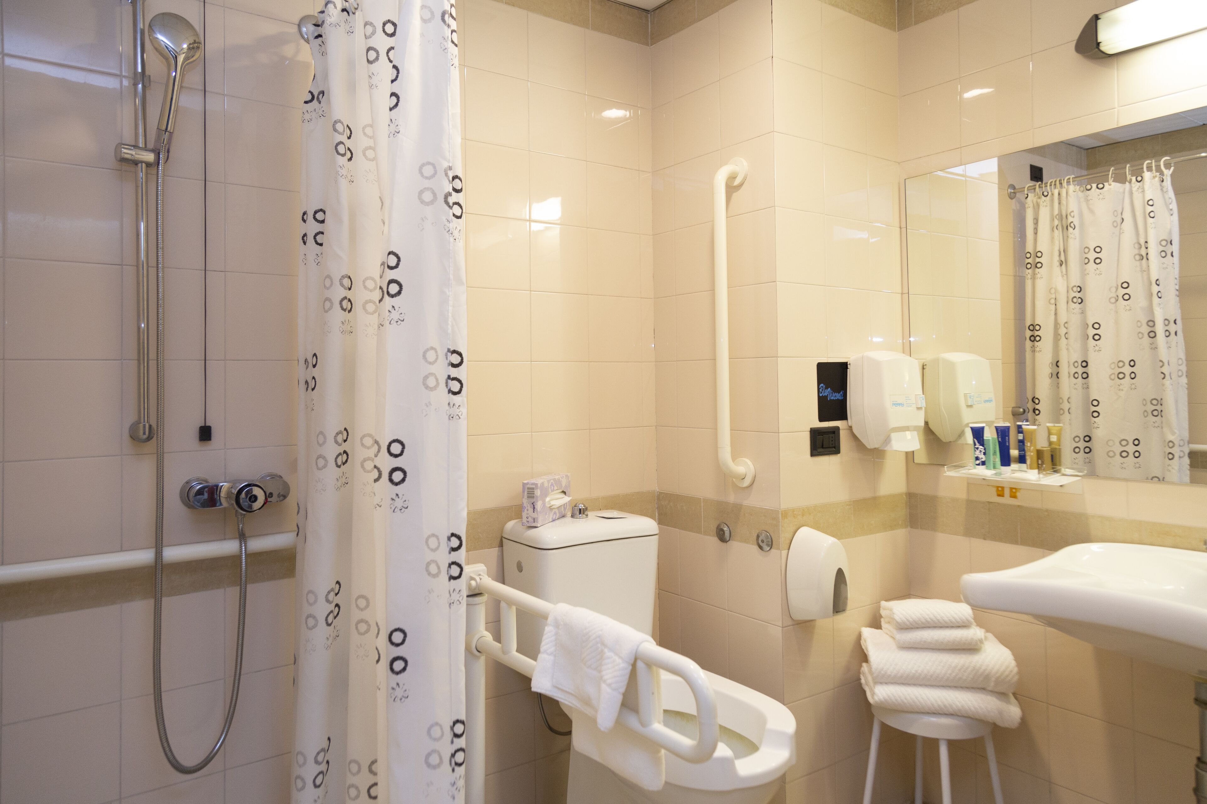 A modern bathroom with a shower, toilet, and sink.