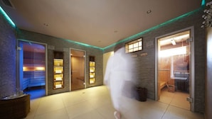 Un vestíbulo de hotel con diseño moderno, que incluye una zona de recepción, un área de descanso y una sauna visible.
