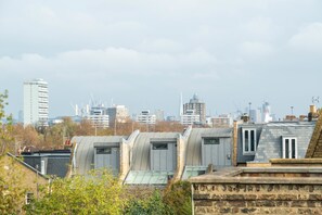 A cityscape with modern buildings and a row of green-roofed structures. - Immaculate Designer Home in Wandsworth (London)